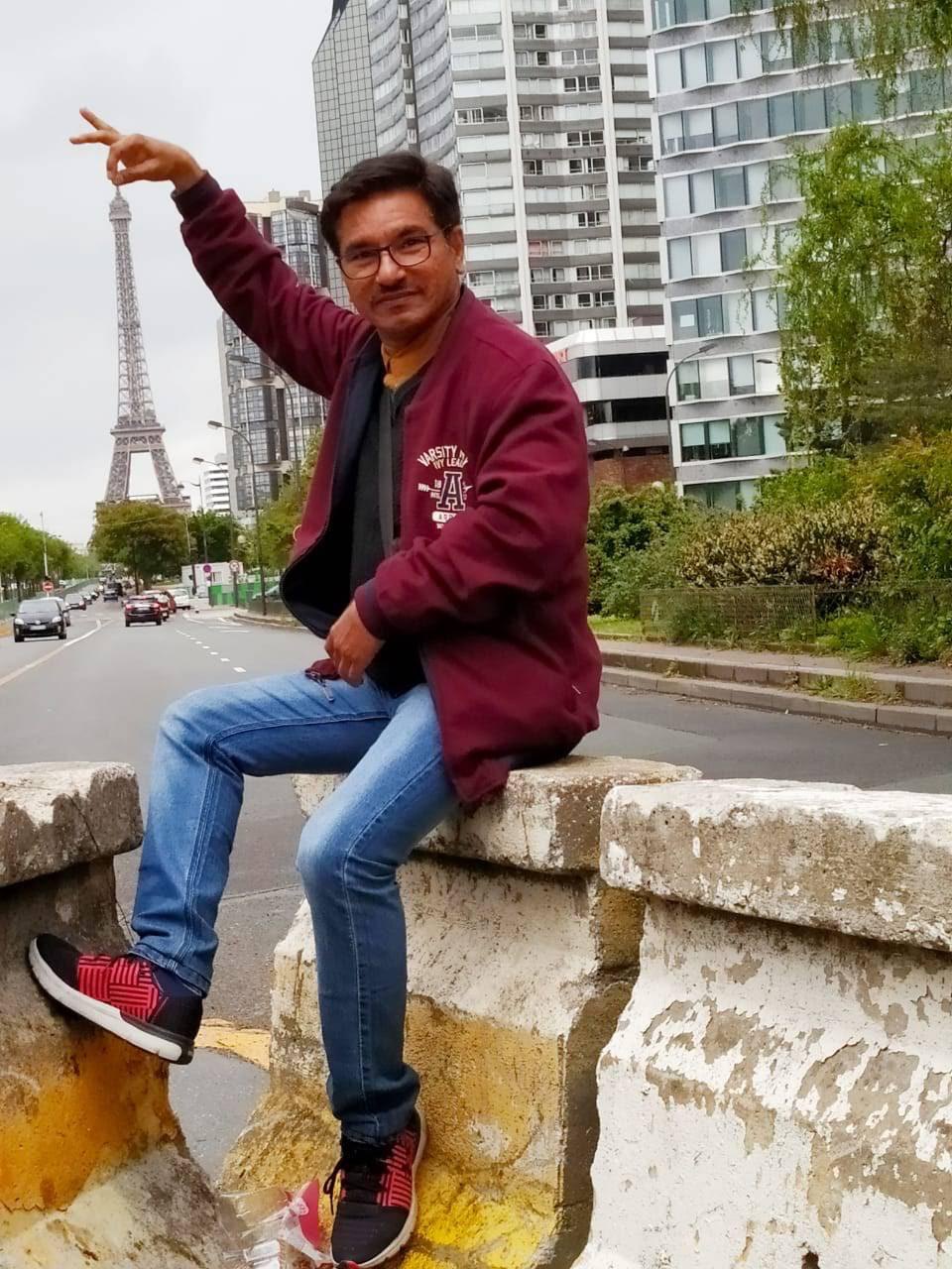Mr Batheja in Paris with the Eiffel Tower behind him
